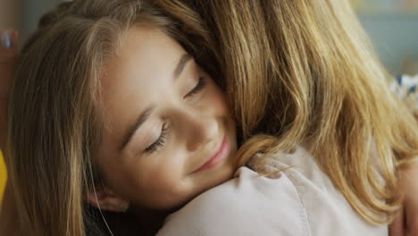 close up of teen girl hugging her mother and smiling