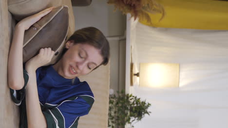 vertical video of young woman lying on the sofa is resting.