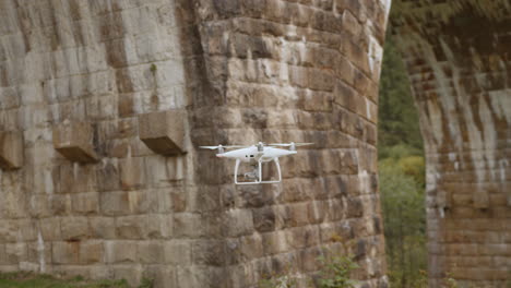 drone flying over an old stone bridge