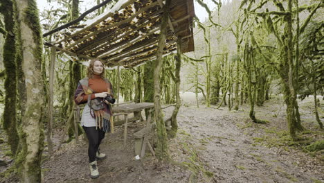 woman photographer in a mossy forest shelter