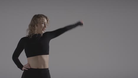 foto de estudio de una joven haciendo práctica de baile con fondo gris 2