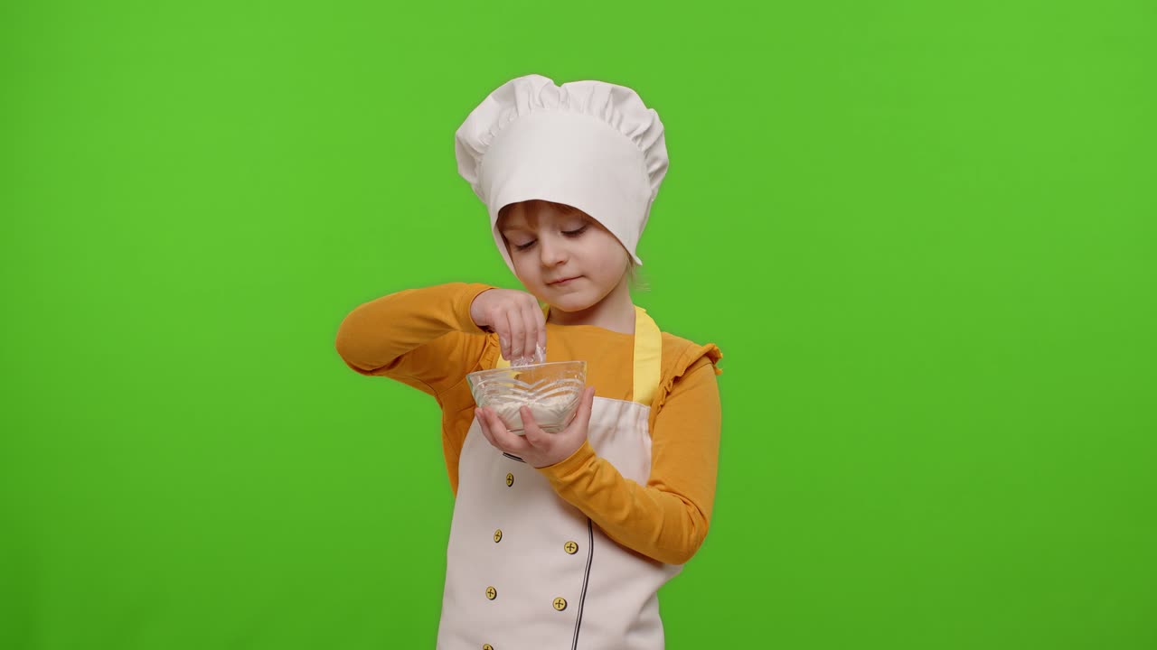 Bambina vestita con grembiule e cappello da cuoca che mescola la farina in un piatto su sfondo chroma key