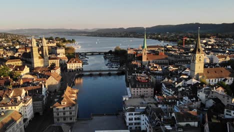 aerial flyover over zurich, switzerland above limamat river with views of the various churches, rooftops, and lake