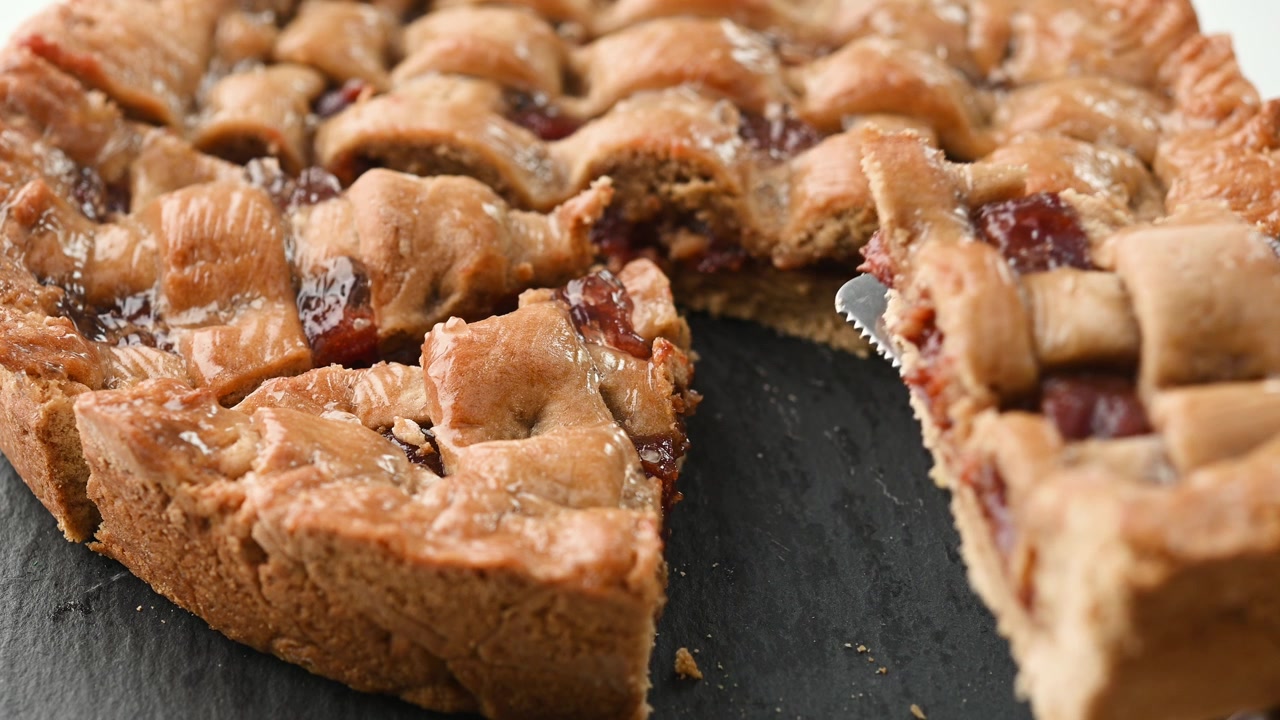 Crostata di frutta con reticolo servita su un vassoio di ardesia.