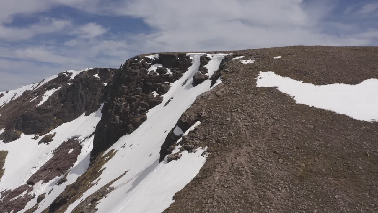 acantilado de montaña de escocia cubierto de nieve tiro de drone revelar