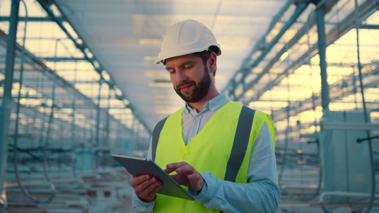 ingeniero feliz con una tableta recopilando datos de producción analizando la eficiencia