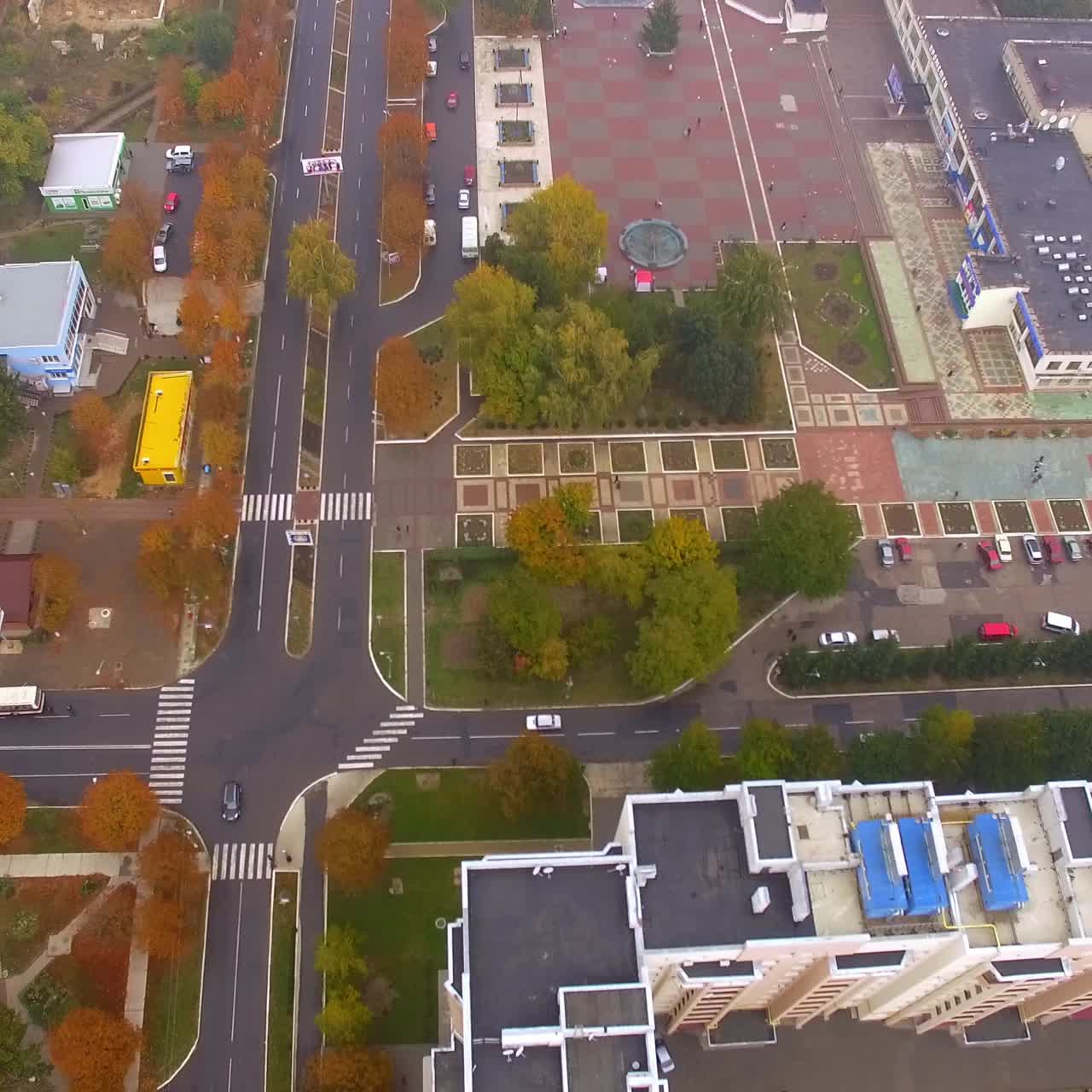 Bigger and smaller blocks of flats in the city downtown. Main roads with few cars passing by. Autumn foggy day backdrop
