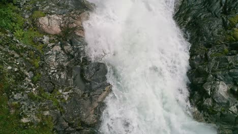 aerial flyover of ovstefoss waterfalls rapids curving between rocks in slow motion