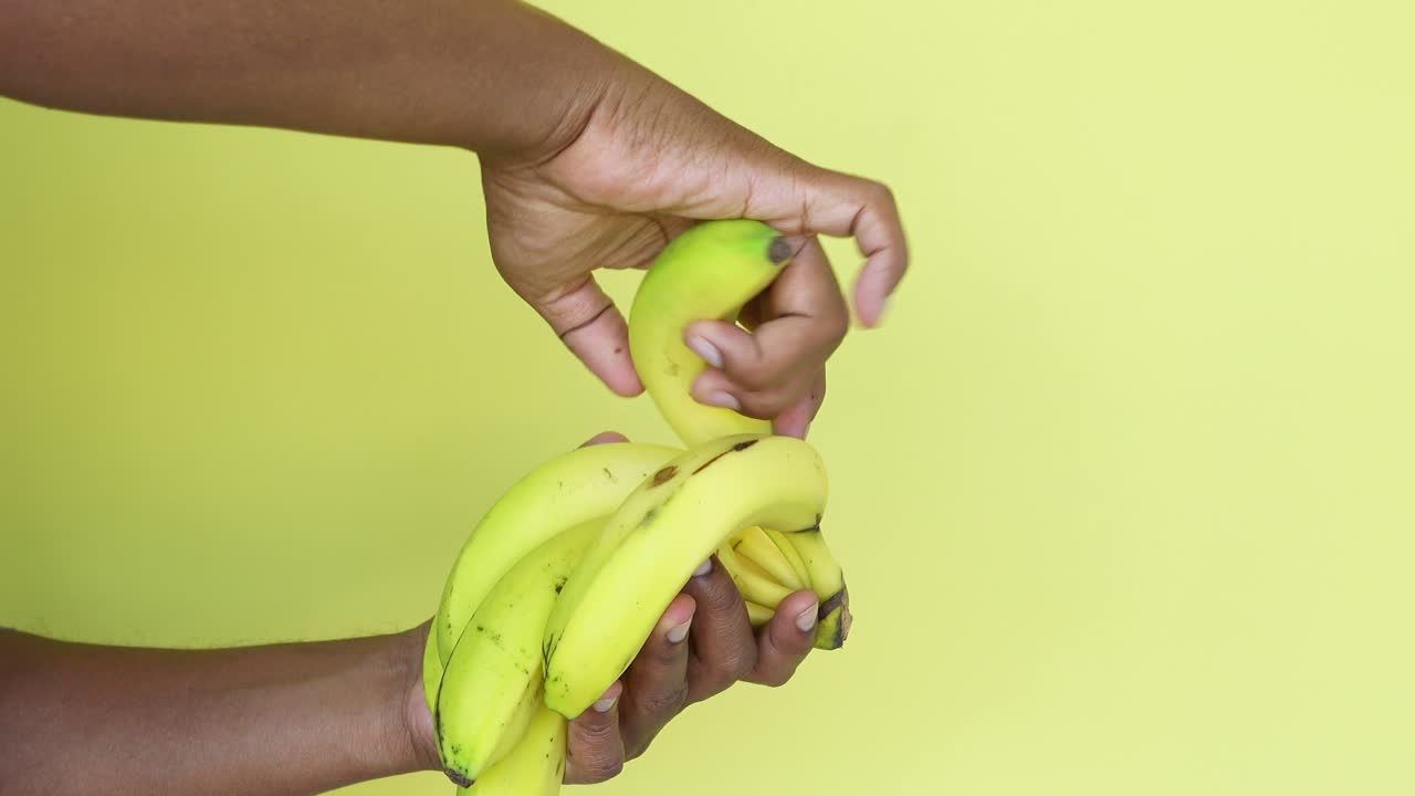 바나나 한 어리를 들고 있는 손