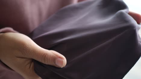 closeup of a hand holding brown fabric