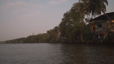 an establishing truck pan of the beautiful scenic view overlooking the mandovi river and the luxury houses built on the riverbank, goa, india