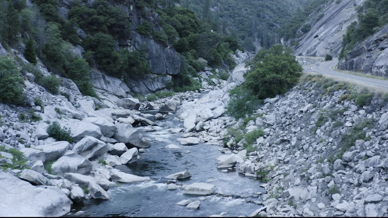 Ripresa aerea in avanti sopra una valle fluviale piena di grandi massi e rocce.
