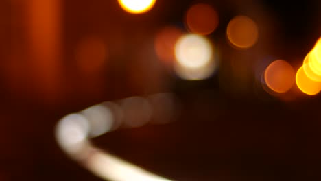 escena de bokeh borrosa en la ciudad por la noche con con colores cálidos mientras la gente camina por.