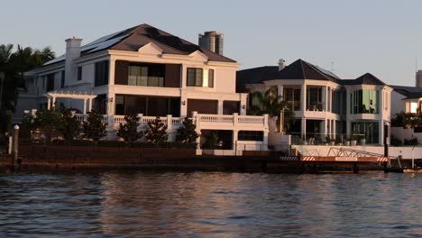 luxury houses along a calm waterway at dusk