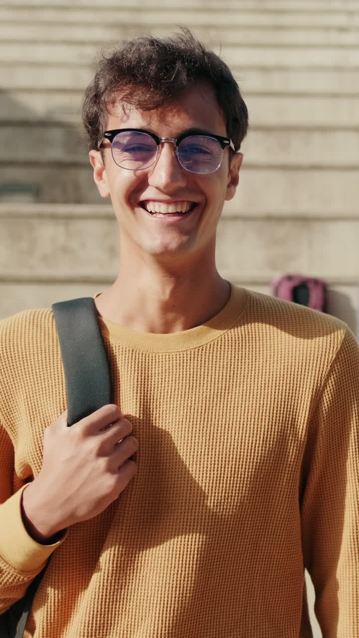 Сheerful European boy with glasses, male student with his friends in the