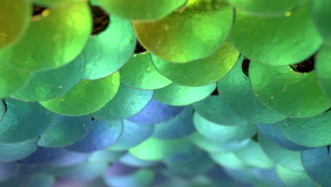 Lentejuelas-Azules,-Verde-Azulado,-Verdes-Y-Amarillas-De-Colores-Brillantes-Que-Se-Mueven-De-Arriba-A-Abajo