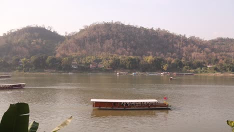 boats-floating-down-the-mekong-river-in-Luang-Prabang,-Laos-traveling-Southeast-Asia