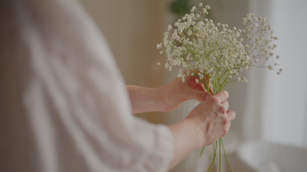 Close Up of Hands Gently Holding Pregnant Belly with Flowers