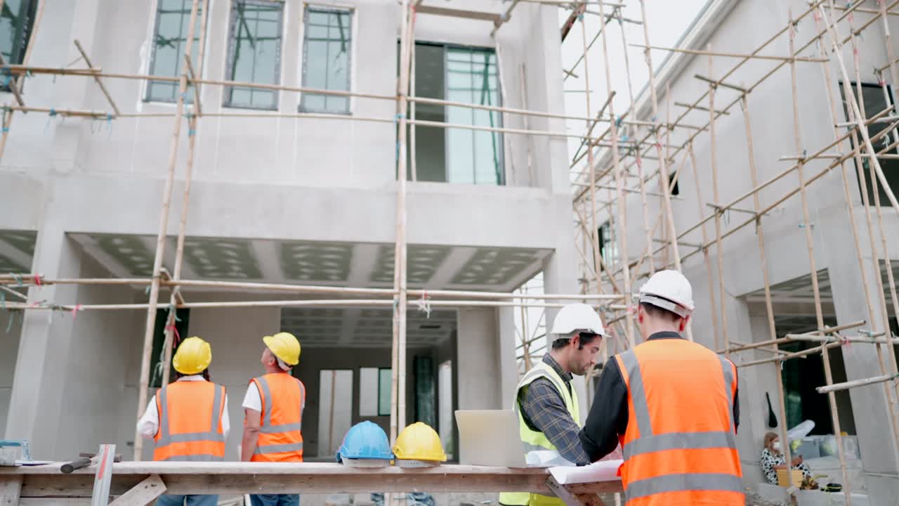 equipo de contratistas profesionales multirraciales está trabajando en el sitio de construcción de viviendas. arquitecto masculino caucásico o ingeniero civil hablando con forman sobre el progreso de la construcción de la casa del proyecto de vivienda. concepto de negocio inmobiliario.
