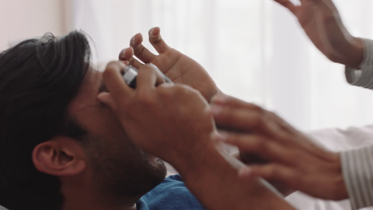 행복한 커플이 카메라를 사용하여 함께 사진을 찍고 침대에서 집에서 재미있게 로맨틱한 관계를 즐기며 서로 사진을 찍고 있습니다.