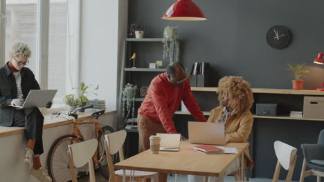 african american coworkers using laptop at work in office