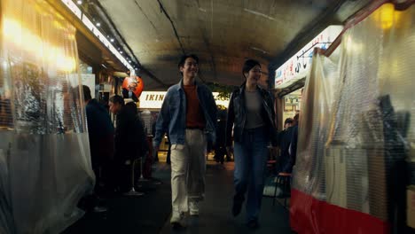 couple walking through a night market in japan