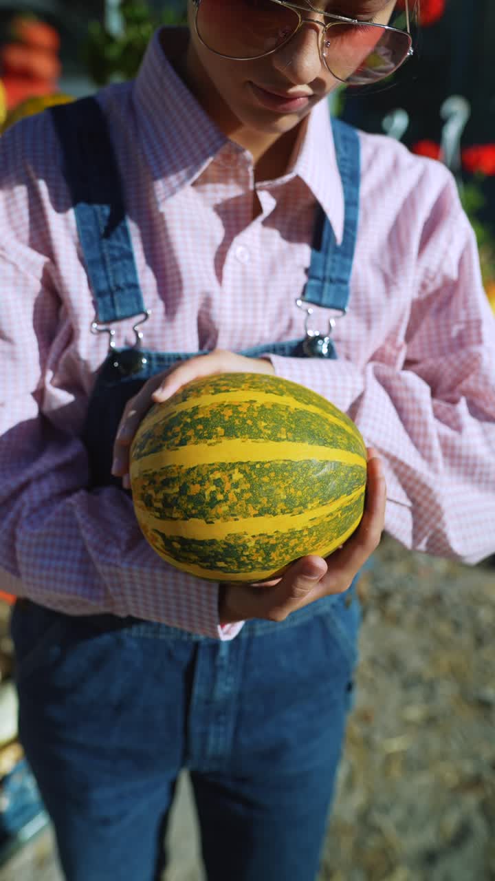 un adolescente con una calabaza en la mano