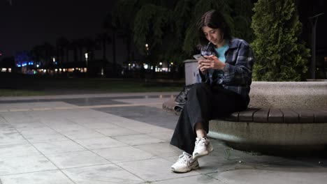 Girl-messaging-on-bench