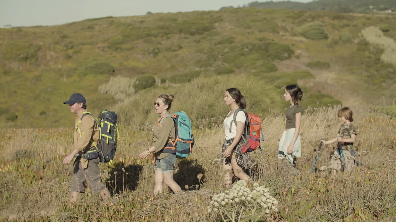 배낭을 메고 등산로를 따라 걷는 행복한 가족의 모습