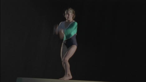 a young gymnast performs a routine on a bar