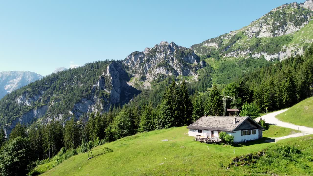 Splendida vista aerea cinematografica di una casa su pendii verdi ad alta quota nelle Alpi austriache
