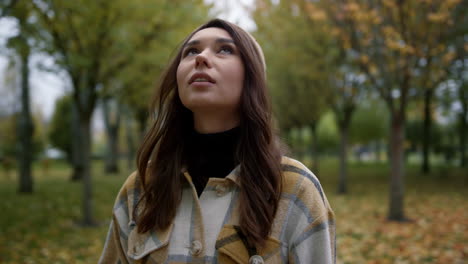 Mujer-Joven-Sonriente-Mirando-Alrededor-En-El-Parque-De-Follaje