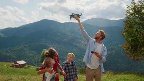 Happy-family-using-drone-on-walk-mountains.-Man-launching-quadcopter-from-hand.