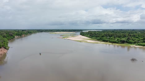 aerial top down shot flying backward tilting the camera up revealing a big river in selous, tanzania.