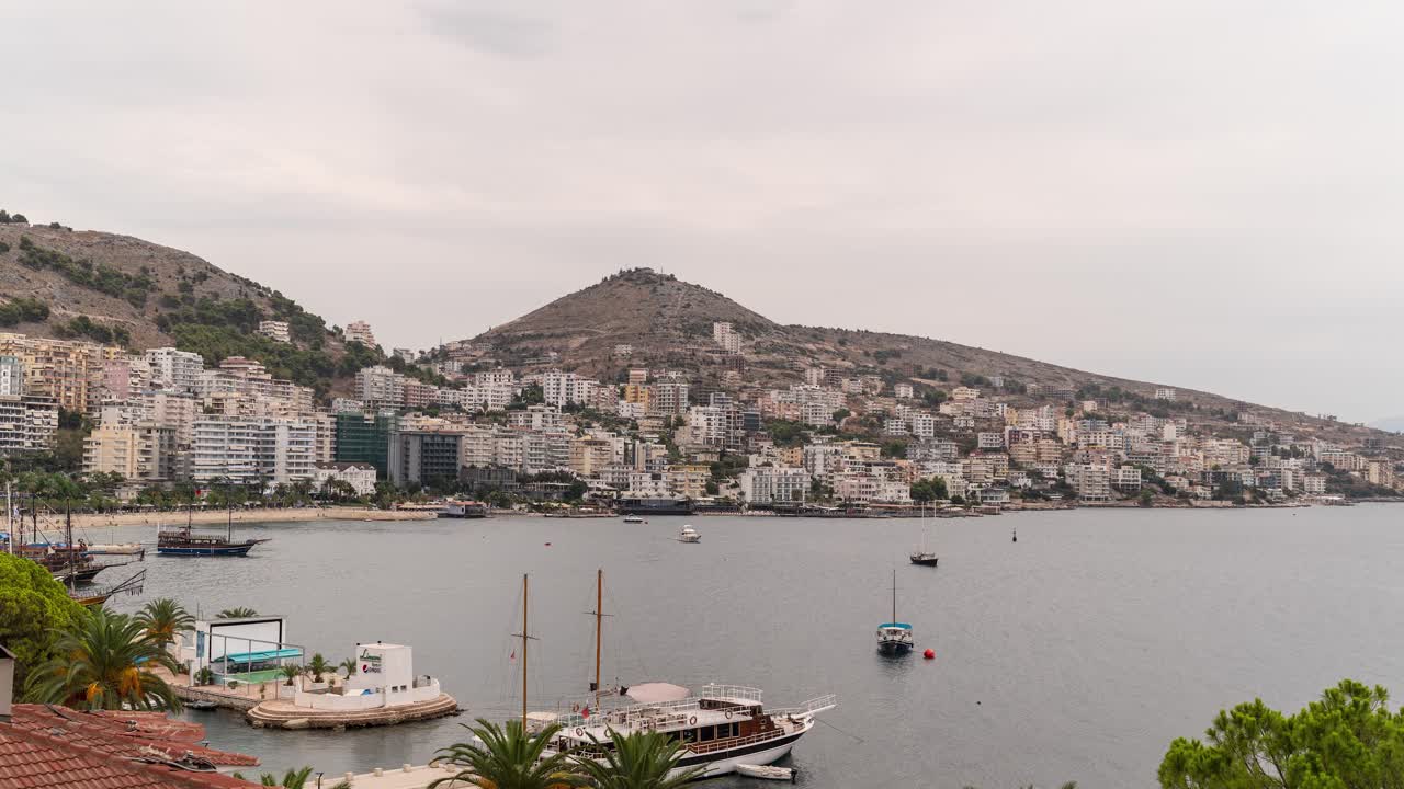Fast timelapse over beautiful city of Saranda with ocean and boats in Albania