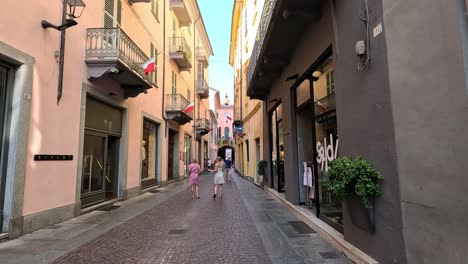 people walking past shops in alba, italy