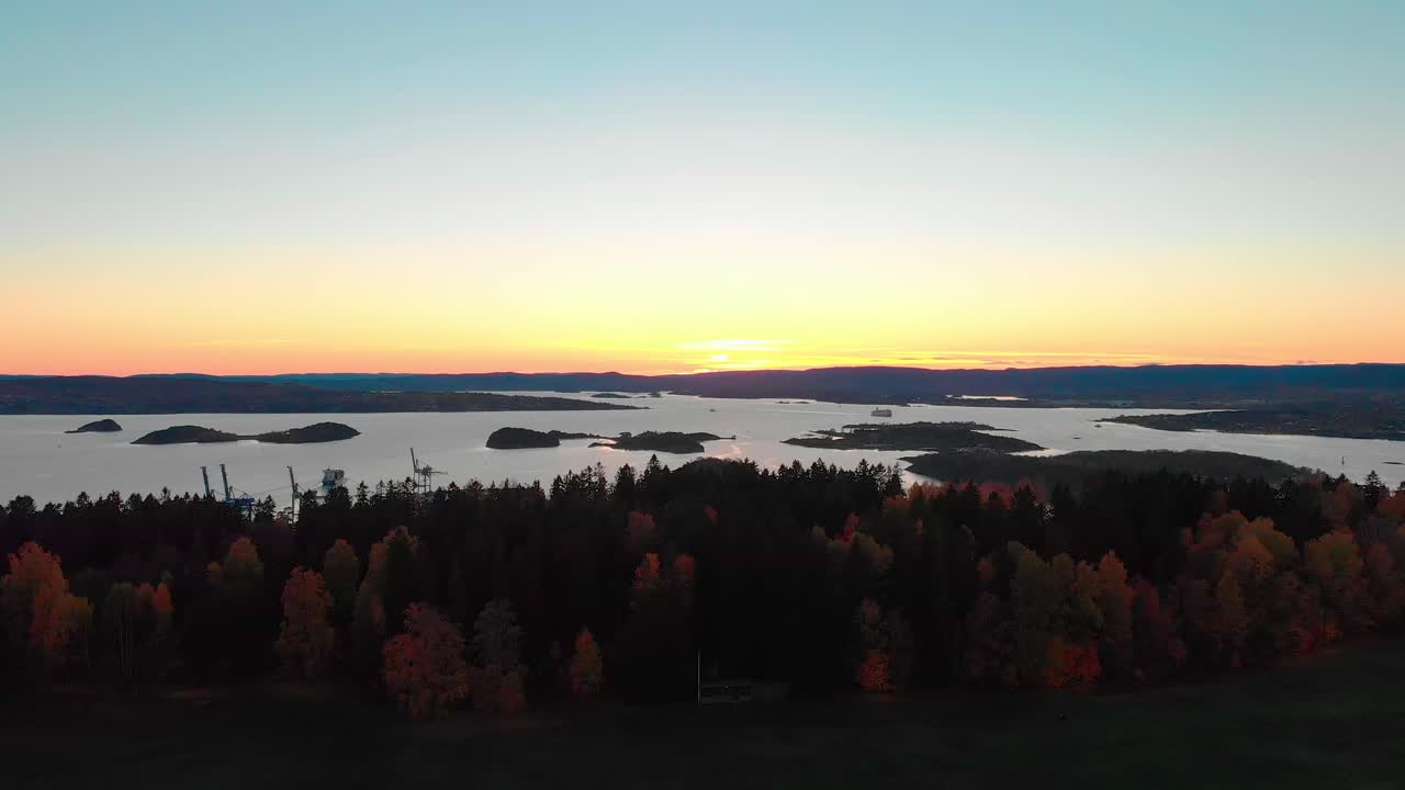 Slow rising evening aerial shot of Norwegian fjord showing bog boats and islands