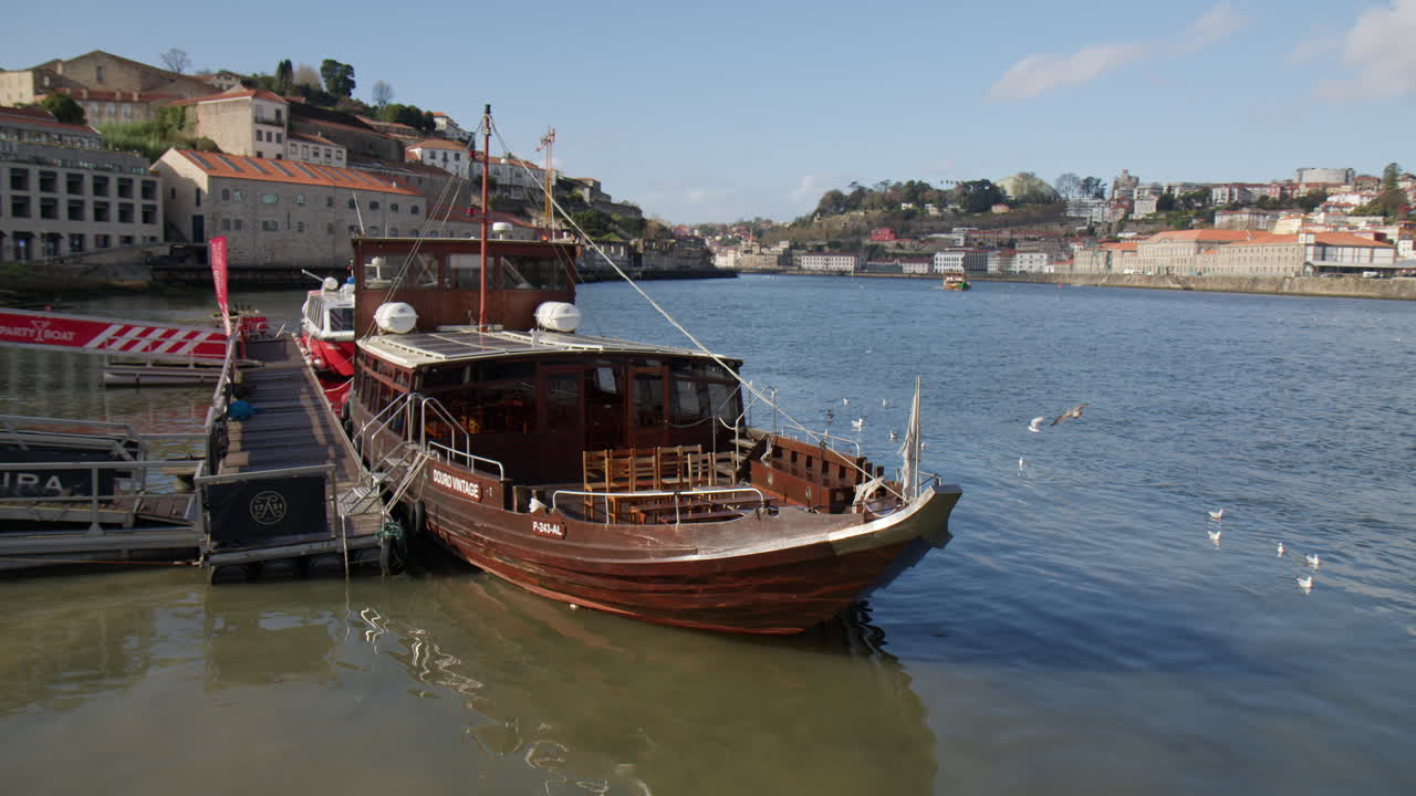 Rabelo Boat Docked At Harbour On Douro River In Porto, Portugal. wide shot, slow motion