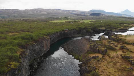 imágenes aéreas sobre un hermoso río proveniente de la cascada glanni en islandia