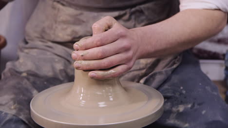 the hands of a potter make a jug on a potter's wheel 4