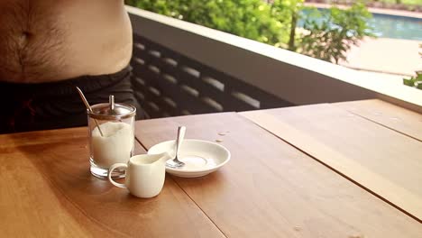 a man enjoying a cup of cafe americano after a quick swim on the pool during a relaxing summer holiday vacation