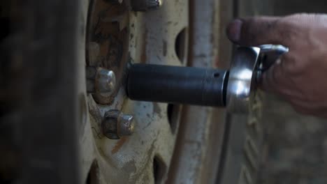 extreme close up tightening lug nuts on tire with ratchet and socket, automotive repair