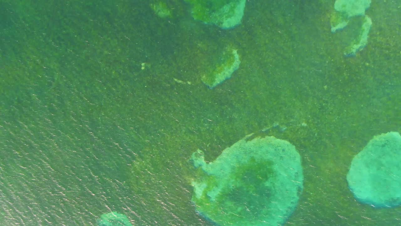 Underwater ocean emerald color rock formation submerged, aerial top-down view