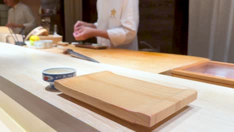 chef prepares and serves sushi to customer