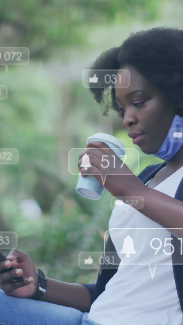 Animation of social media icons over african american woman using smartphone sitting on the bench