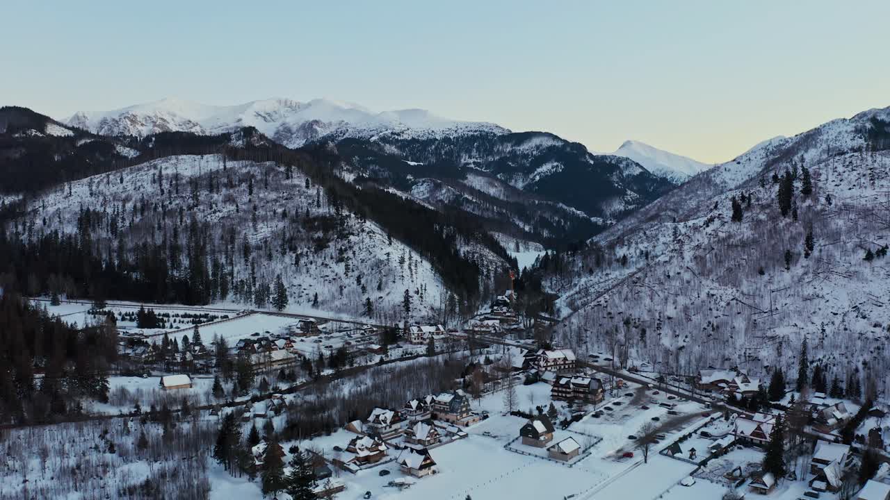 hermosa toma aérea de un paisaje nevado con casas polacas tradicionales al atardecer - kościelisko