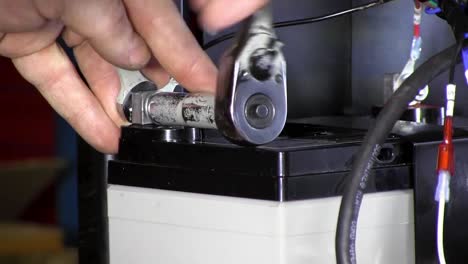 tightening a bolt with a socket wrench and open ended wrench close up