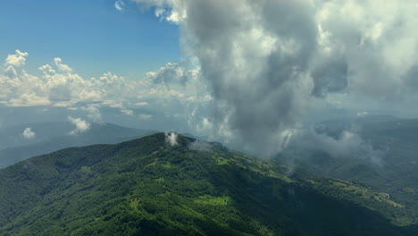 volando a través de nubes blancas y esponjosas por encima de los picos verdes de las montañas