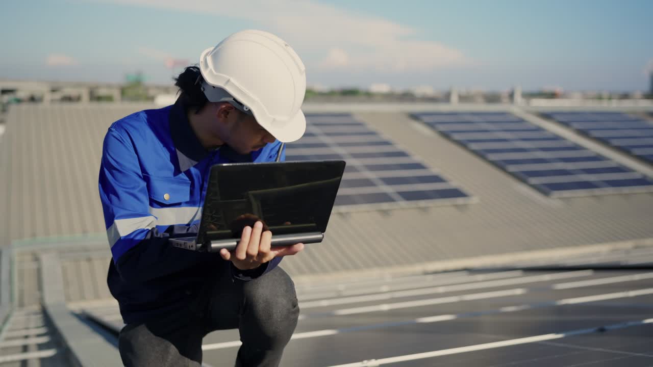 Specialist technician professional engineer with laptop and tablet maintenance checking installing solar roof panel on the factory rooftop under sunlight. Engineers holding tablet check solar roof.