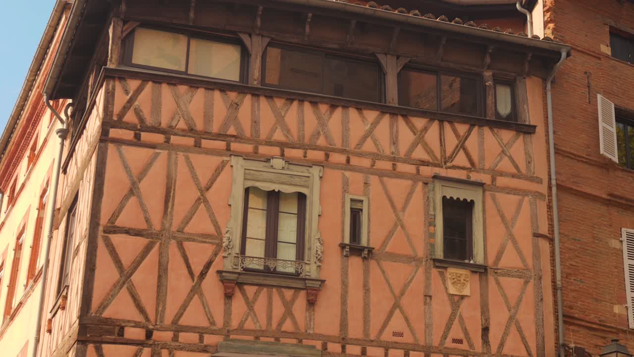 Historic Half-timbered Building In Toulouse, France, With Peach-colored Walls, Wooden Beams, And Ornate Windows. closeup shot
